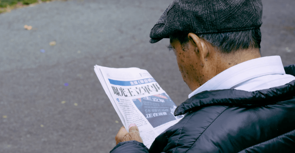 Rechtenvrije foto van een oudere heer die een nieuwsbrief leest.