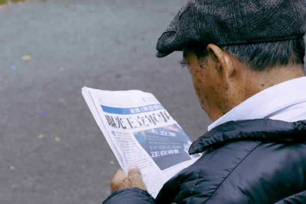 Rechtenvrije foto van een oudere heer die een nieuwsbrief leest.